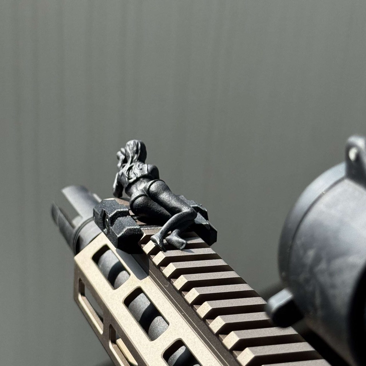 Spotter G rail charm reclining on an airsoft handguard, top angle