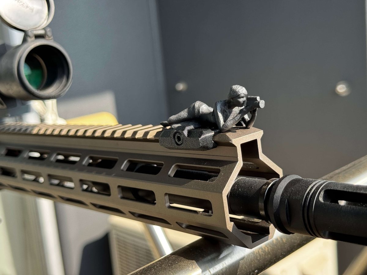 Spotter G prone on a rifle rail in natural light